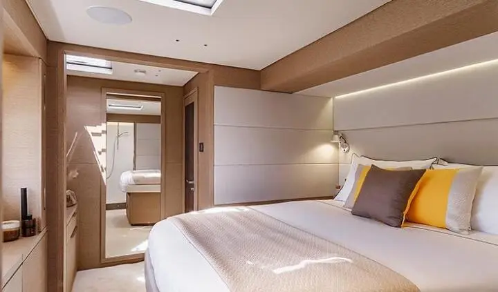 Daiquiri yacht cabin interior with a large bed, neutral tones, and decorative pillows