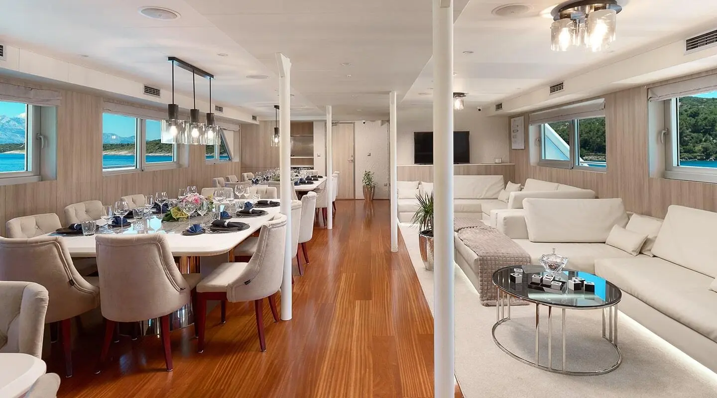 Cristal yacht dining area with wooden floor, white seating, and tables