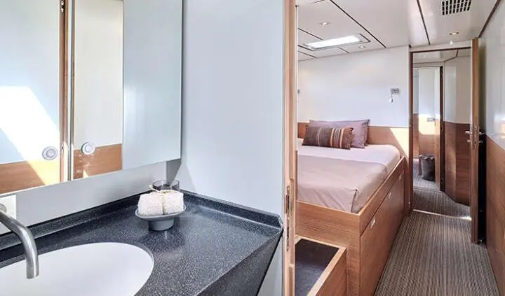 Aizu yacht cabin with bed, wood flooring, and small ensuite sink area