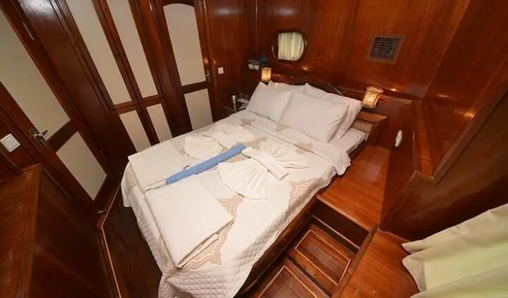Master cabin with king bed, white linens, wood walls and ensuite, on Prenses Bugce
