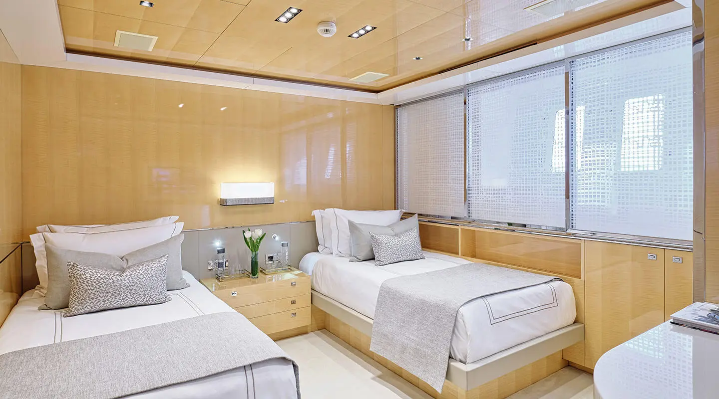 La Pellegrina 1 yacht interior: bright cabin with two white beds, wooden panels, and large window view