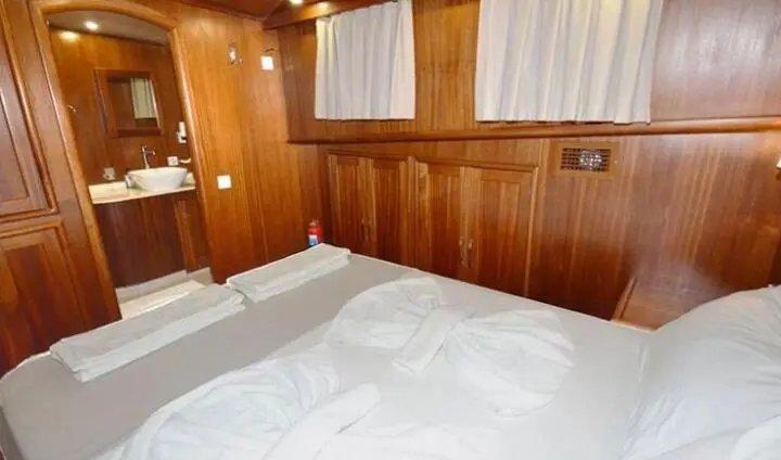 Cozy cabin interior on Prenses Esila yacht with wooden walls and bed