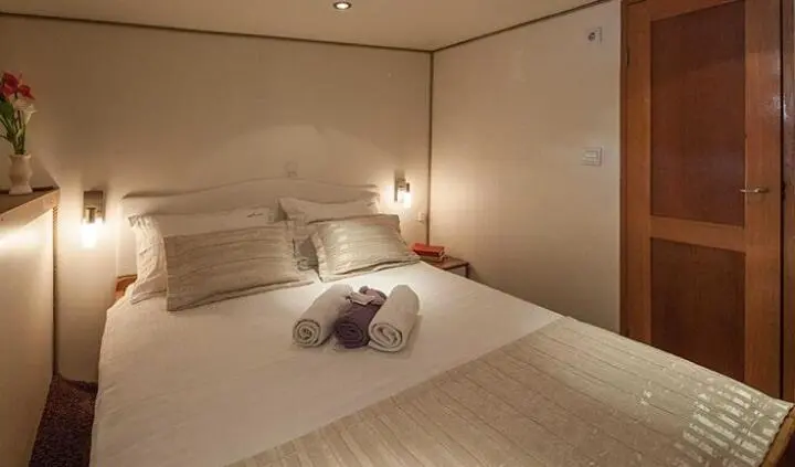 Romanca yacht cabin with double bed and ensuite layout, two towels neatly placed