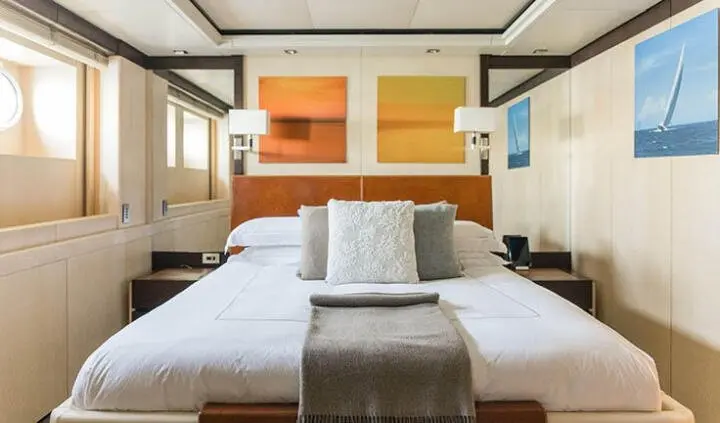 Master cabin with king bed, neutral tones, wood accents, two nightstands