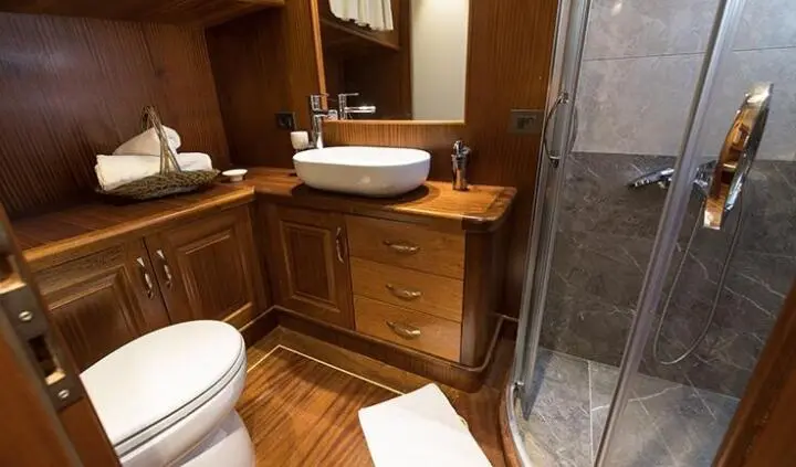 Master cabin with king bed, wooden cabinetry, and ensuite visible