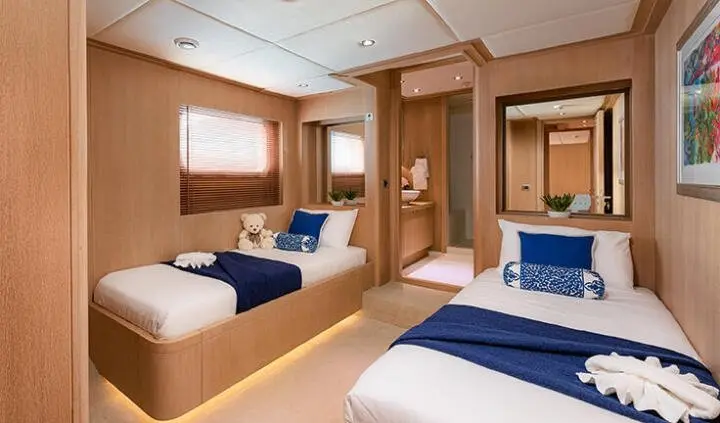 Twin cabin aboard Grace: two single beds with blue linens and ensuite door