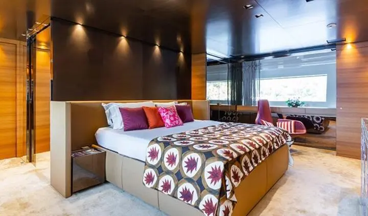 Takara One master cabin with king bed, ensuite visible, wood tones, decorative pillows