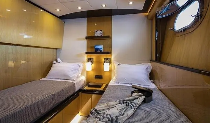 Twin cabin with two single beds, wood accents, and a central bed runner