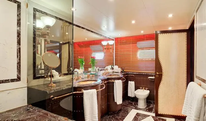 Mobius yacht cabin with made bed, wood panels, and ensuite bathroom visible
