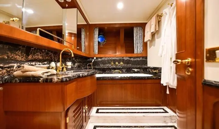Tamarita cabin ensuite with wooden cabinetry, sink, mirror, and bed area