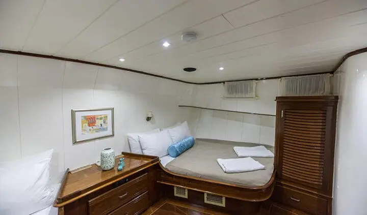 Twin cabin with railbed, ensuite, porthole light, wood cabinets, white bedding