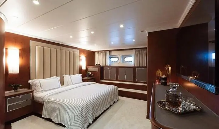 Ocean Breeze master cabin with two beds, warm lighting, and wood accents