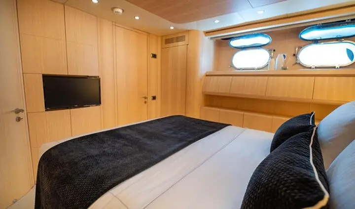 Pareaki II master cabin with king bed, wood paneling, window, and ensuite door