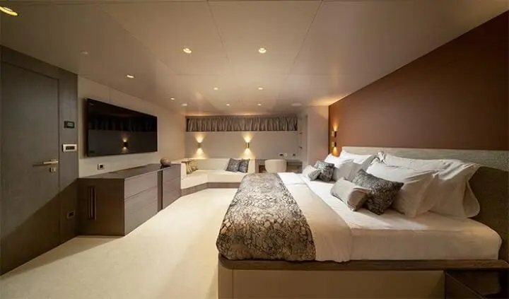 Nocturno master cabin with king bed, wood headboard, bedside lamps, and ensuite door
