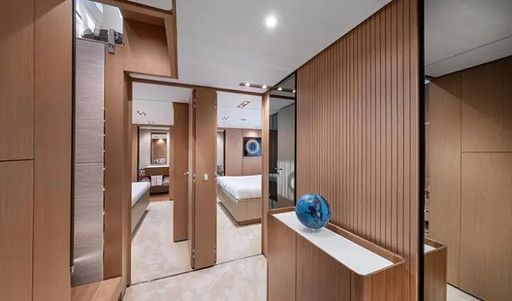 Spica yacht cabin with king bed, ensuite, wood-paneled walls, and blue decor