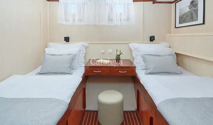 Twin cabin on Cataleya yacht with two single beds and center shared table
