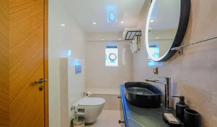 King Of The Sea master cabin with large bed, ensuite bathroom, circular mirror