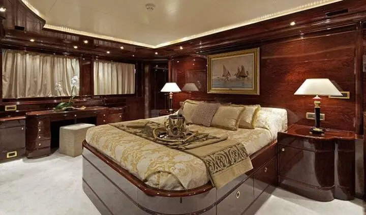 Opulent O'Rion cabin interior with king bed, rich wood paneling, and ambient lighting