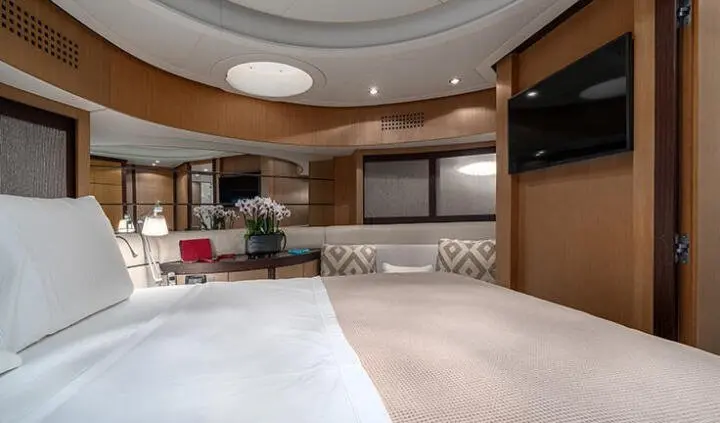 King bed in a cabin with beige bedding and soft lighting, adjacent seating area