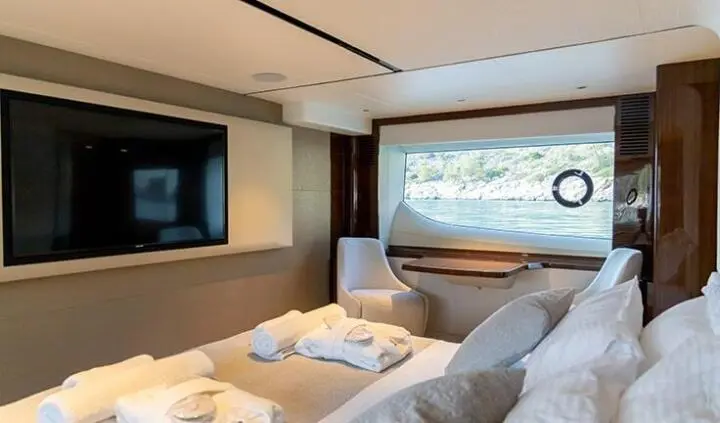 Vista yacht cabin with king bed, window view, neutral bedding and seating