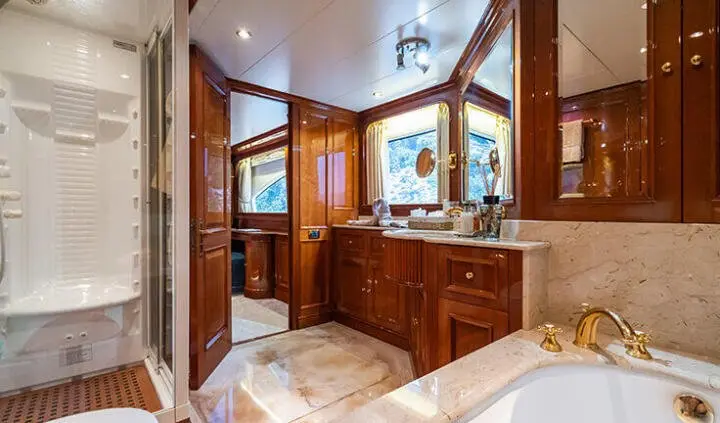 Amadea cabin with king bed, wooden cabinetry, and porthole window