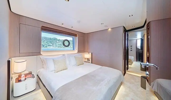 Master cabin with king bed, wood-paneled walls and ensuite door visible