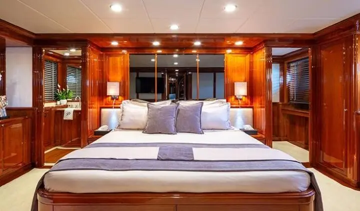 Divine cabin with king bed, blue pillows, wooden walls, and warm lighting