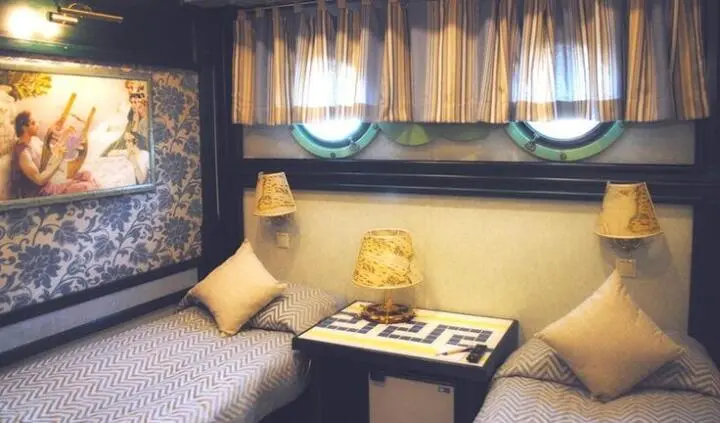 Cozy cabin interior with blue cushions, small table, and window view
