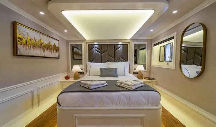 Queen Of Makri cabin bed with ensuite nearby, wide yacht interior view