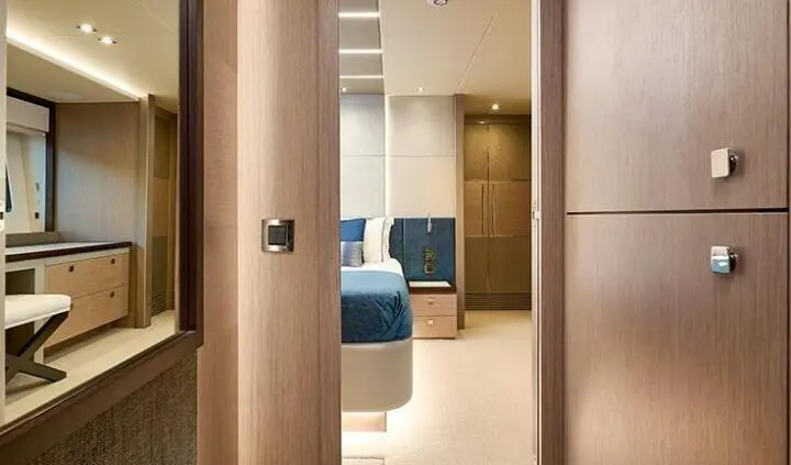 Master cabin with king bed and ensuite, through doorway to blue seating area