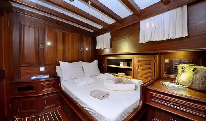 Twin berths with white linens in wood-paneled cabin aboard Samarkand