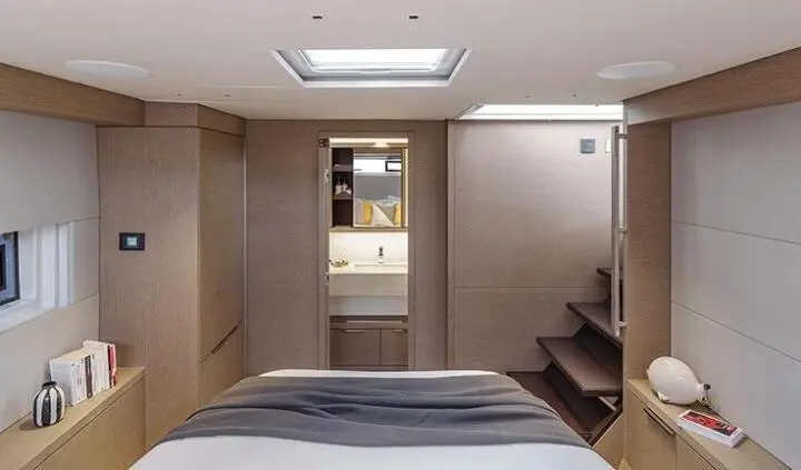 Two twin beds with striped blankets in a cabin, doorway to ensuite ahead