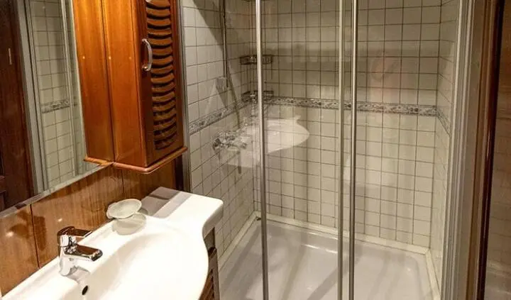 Bathroom cabin with glass shower enclosure and tiled walls aboard Kayhan Kaptan