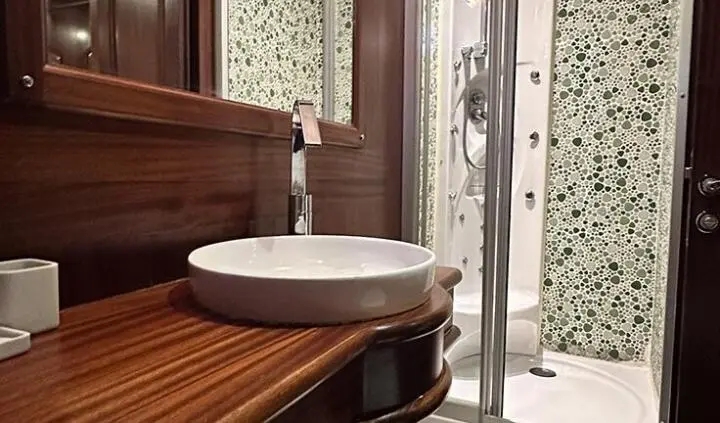 Bathroom sink on wooden cabinet with towel, marble wall, cabinHint