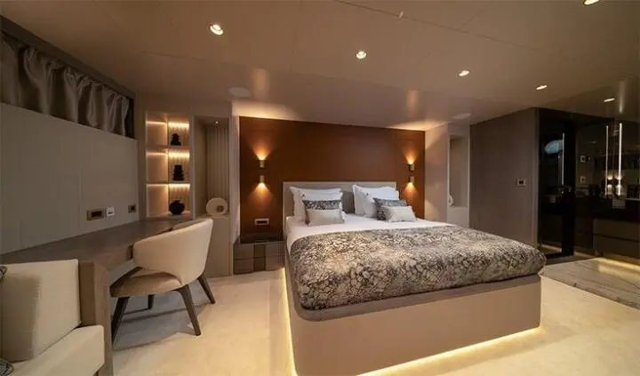 Nocturno yacht cabin interior with large bed, nightstands, and seating area