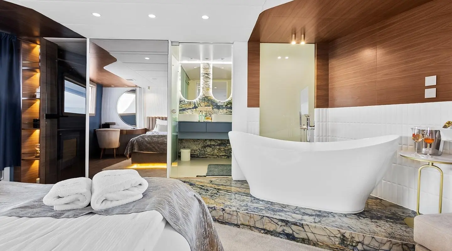Interior of Bella yacht with luxurious lounge, large windows, and bed