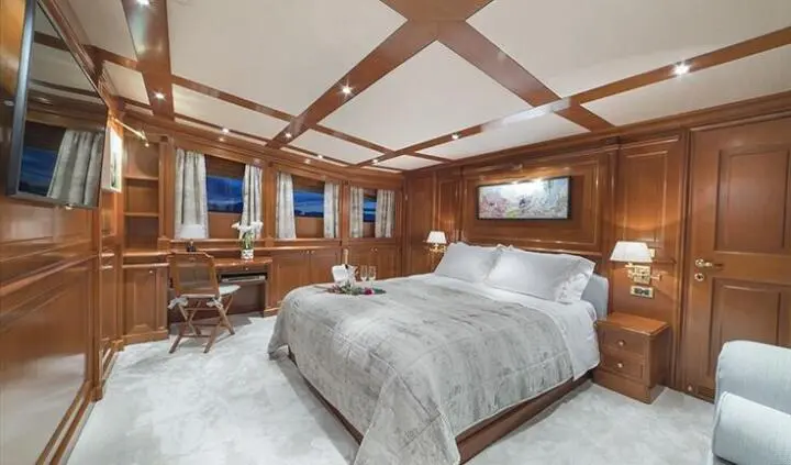 Aquila yacht master cabin with king bed, wooden beams, and ensuite area