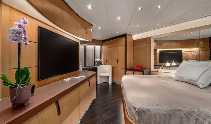 Spacious yacht cabin with king bed, ensuite doorway, warm wood accents