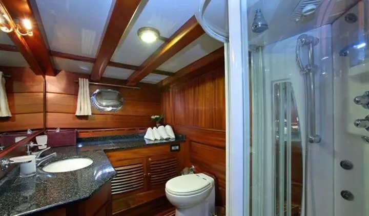 Master cabin with king bed, wood paneling, and built-in storage on Kaya Guneri 4