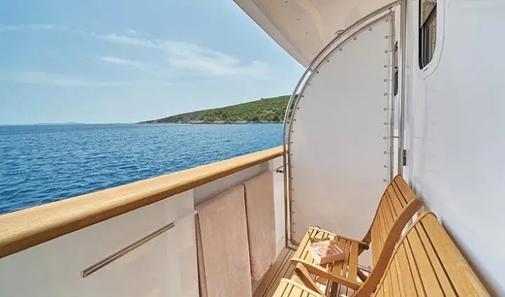 Balcony cabin interior with railing and ocean view from La Perla yacht