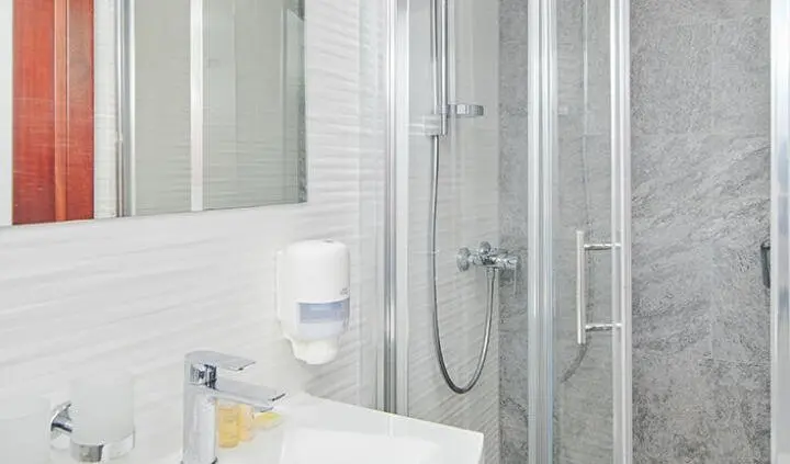 Lupus Mare cabin interior with sleek white surfaces and glass shower enclosure