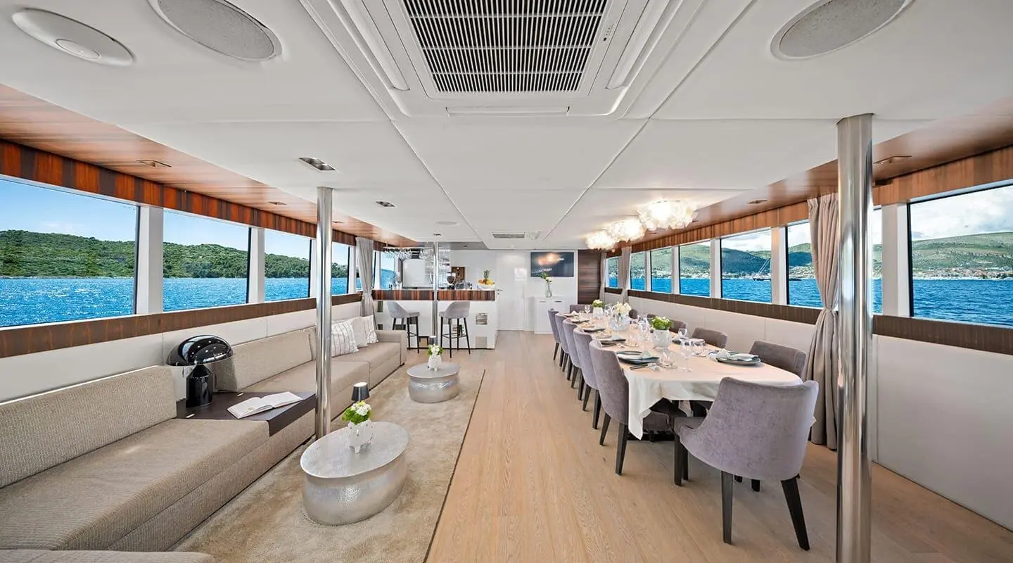 Dalmatino yacht dining area on deck at sunset with tables and chairs