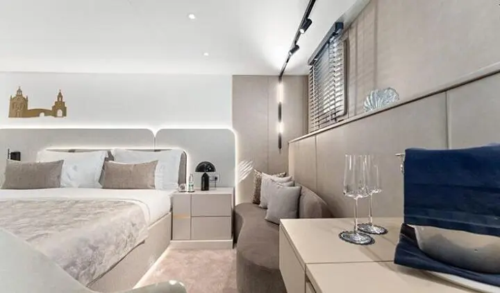 Master cabin with king bed, beige upholstery, ensuite visible, soft lighting