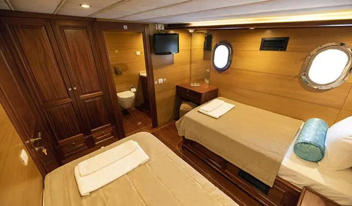 Twin cabin with two single beds and ensuite bathroom in yacht interior