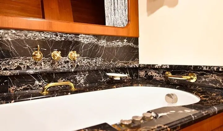 Luxurious Tamarita cabin bathroom with marble countertop and gold fixtures
