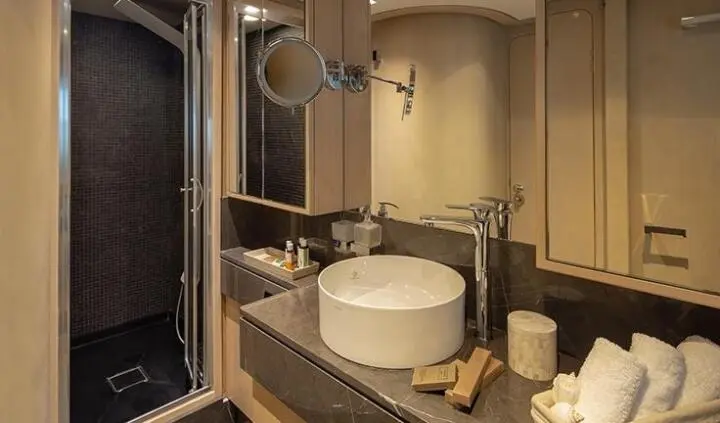 Bathroom vanity on a yacht interior with sink, mirror, and toiletries