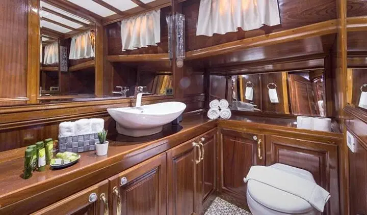 Grace 1 cabin interior with wooden cabinetry, bed, and porthole windows