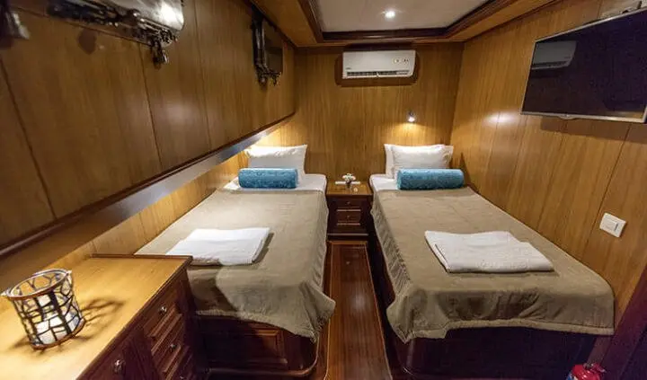 Yacht Kayhan 3 cabin with twin beds and ensuite area in wood-paneled cabin