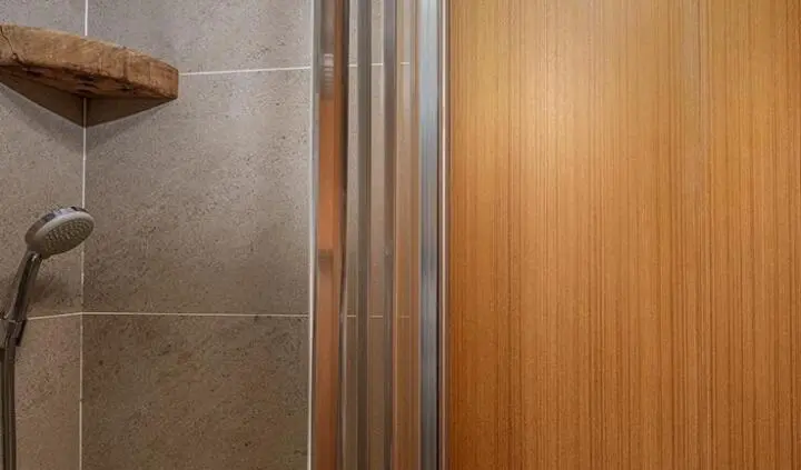 Artemis yacht cabin interior featuring wooden panels and modern shower enclosure