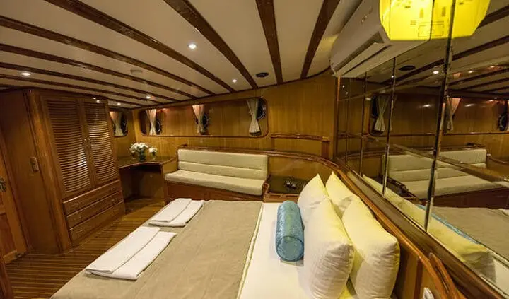 Master cabin with king bed, wood panels, ensuite area and seating